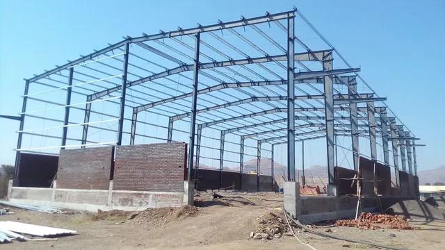 PEB steel structure under construction with masonry walls in progress